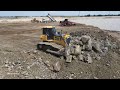 Satisfy operation new SHANTUI bulldozer pushes rock stone in land reclamation on lake