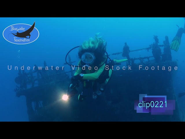 0221_Female scuba diver diving in front of ship wreck. HD Underwater Royalty Free Stock Footage