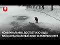 Коммунальник достает изо льда бело-красно-белый флаг в Зеленом Луге