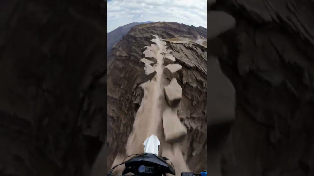 Narrow escape on two wheels—riding the edge as the cliff crumbles beneath me. 🏍️⛰️🔥
