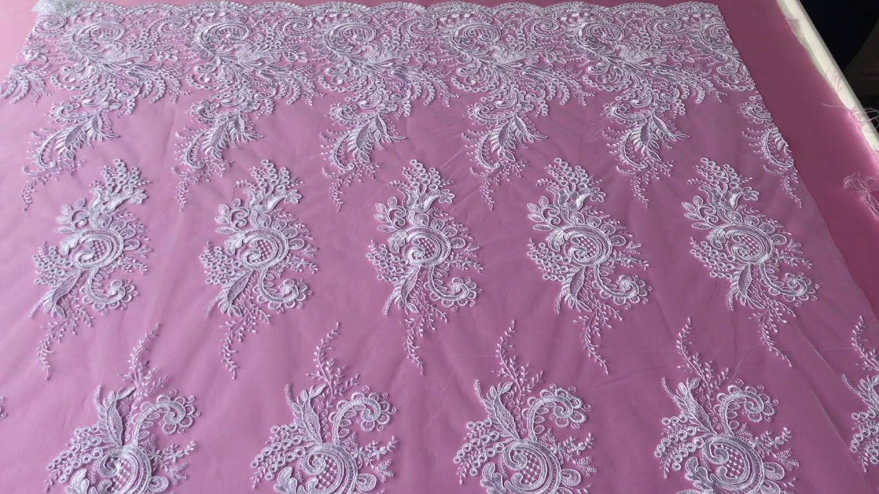 A white bridal lace featuring swirling motifs and a deep border - Boh