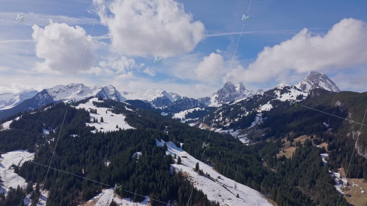 Aerial view of mountains in Gstaad, Swiss Alps, featuring snow capped peaks, green valleys, ski