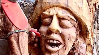 Carving a face on an old wooden trunk