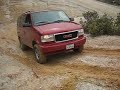 Lifted 4X4 GMC Safari muddy hill climb challenge