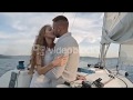 Affectionate couple kissing and hugging each other while sailing on yacht