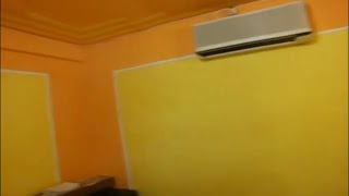 Perpaduan cat warna kuning dan orens pada dinding kamar tidur.