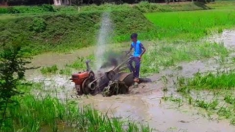 mini tractor, power tiller cultivating in deep mud.