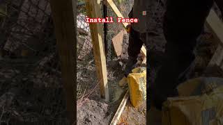 10/25. Construction worker works hard to install fence in the backyard.