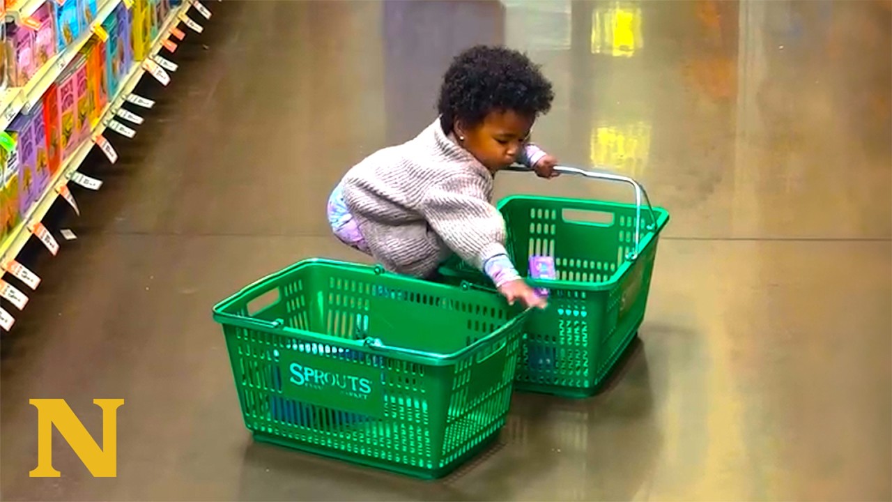 Toddler trying to lift two shopping baskets