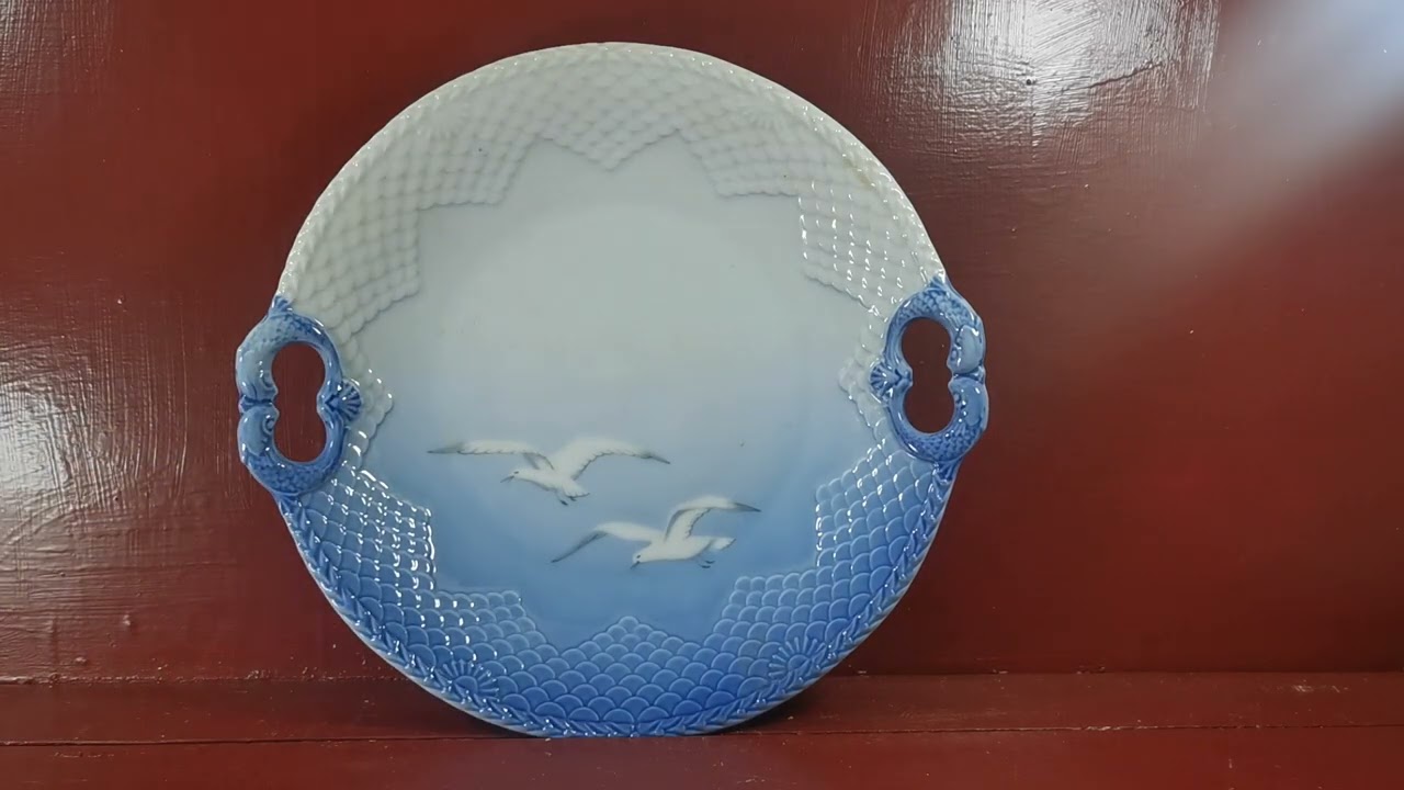 Сервировочная тарелка Royal Copenhagen Denmark сине-белого цвета с изображением чайки и рыбы.