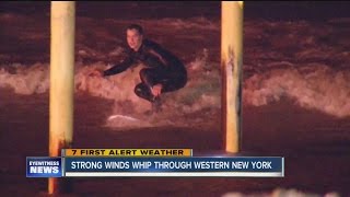 People surf waves caused by high winds