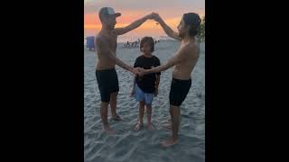Two guys do TikTok flip the kid challenge on beach then boy falls back and lands on sand