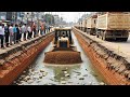 Watch the builders skillfully push sand into the road foundation!