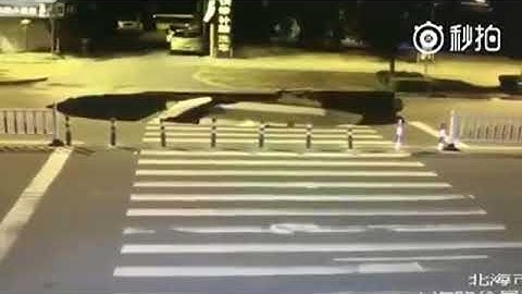 Shocking moment texting scooter rider falls into huge sinkhole