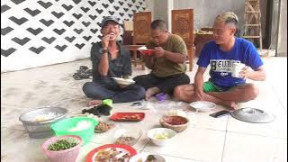 Mang Adeng is eating and being served hotut by Uyan.