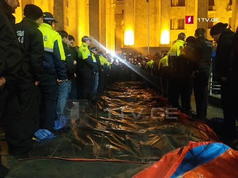 აქციის მონაწილეები მერიის წარმომადგენლებს პარლამენტის წინ ბატუტის გაშლის საშუალებას არ აძლევენ