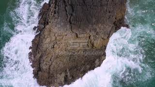 Looking down at waves crashing into rock as birds fly, stock video footage