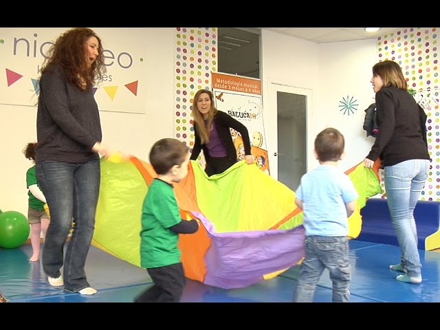 Juego de estimulación psicomotriz para los niños con un paracaídas 