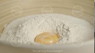 SLOW MOTION: Fresh Chicken Egg Falling Into A Pile Of Flour