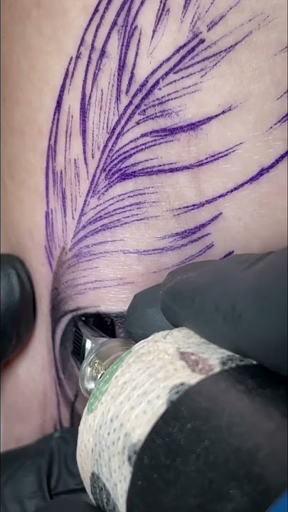 Feather with flowers tattoo