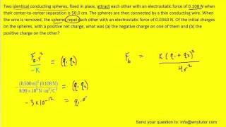 Two identical conducting spheres fixed in place attract each other with an electrostatic force of
