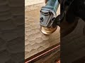 Creating a textured honeycomb pattern on a wood plank using an electric angle grinder