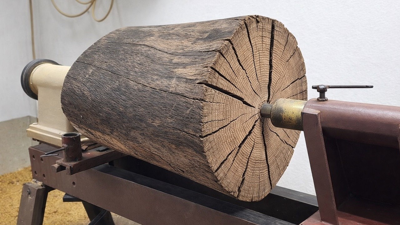 Will that man be able to successfully carve this log with cracks like a desert?