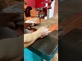 operating a heavy stationary bandsaw machine tool to precisely cut along a curved line on a thick