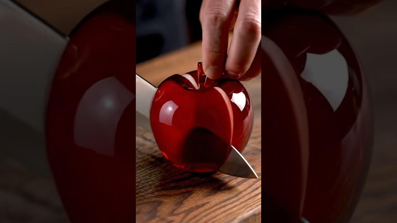 "Red Glass Apple Macro Photography – Shimmering Reflections and Precision Knife Slice"