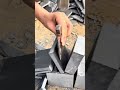 cutting large grey stones into thin pieces using a sharp chisel and a heavy iron hammer tool