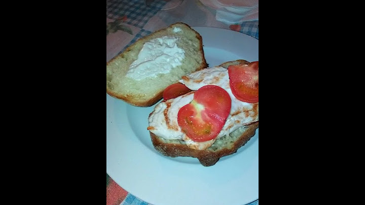 Panino farcito con pollo grigliato, fette di pomodoro e yogurt bianco home-made