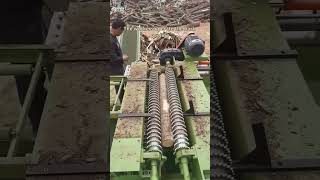 The workers operate the bark peeling machine to peel the bark of the logs