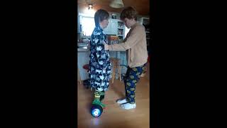 Griffin teaching Turner to ride hoverboard.