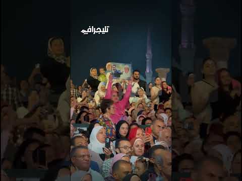 نفسها تديله الصورة معجبة تحمل صورة مدحت صالح بجانب والدته في حفلته بمهرجان الموسيقى والغناء