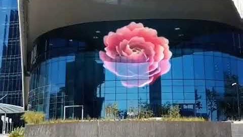 Transparent LED screen lights the architecture building facade with advertising video