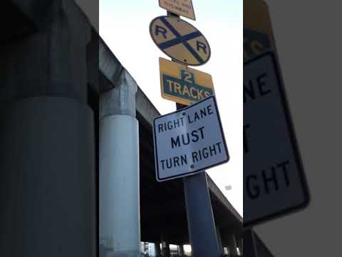 San Francisco Muni trolley bus detaches from dead end wires to battery at Caltrain Railroad Crossing