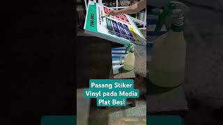 Proses pemasangan stiker vinyl pada media plat besi dengan menggunakan air sabun
