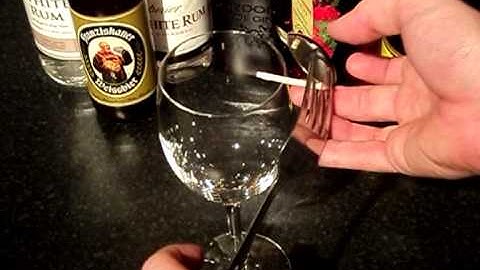 Balancing a fork and spoon on a match on the edge of a glass