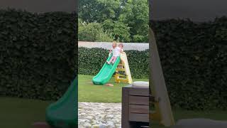 Girl falls from ladder of Green and Yellow Little Tikes slide and bumps head on ground in backyard