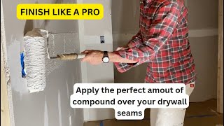 Using a paint roller to apply compound over drywall seams