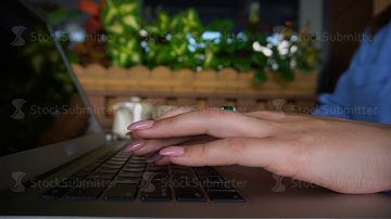 Close up hands typing on laptop keyboard in slow motion