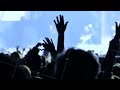 Concert crowd enjoying live dance music, hands raised and forming heart shape
