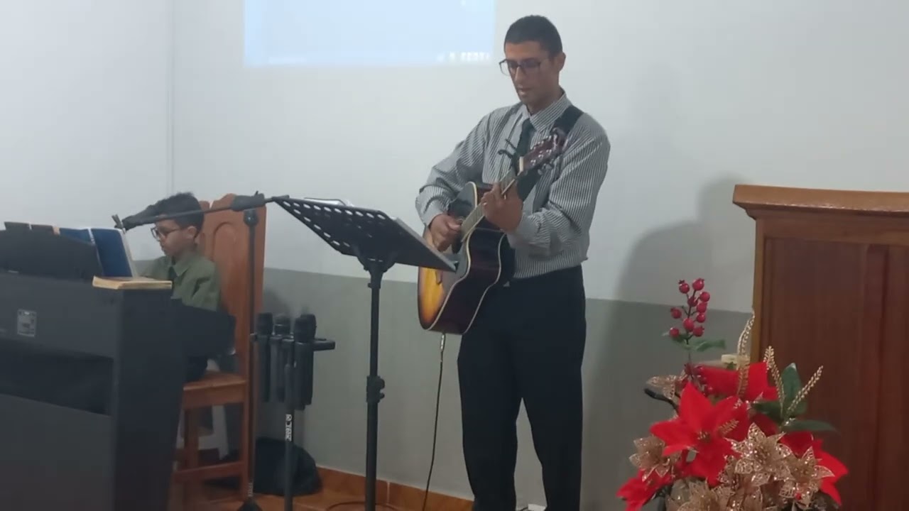 Samuel e o pai tocando o hino: crer e observar na Igreja Batista Bíblica em Sinop MT 
