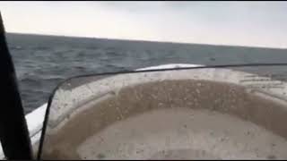 Running fishing boat on rainy day on Lake St. Clair