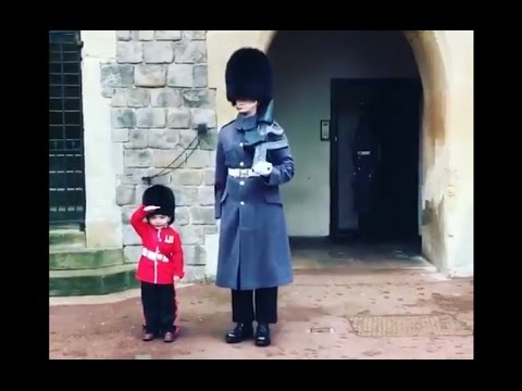 Boy Dressed As British Guard Salutes Windsor Castle Soldiers