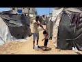 نازحون  يتجمعون للحصول على المياه من شاحنة توزيع في مخيم النصيرات وسط قطاع غزة
