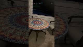 Girl stand and spins on top of round outdoor table then falls headfirst over ledge