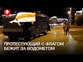 Человек бежит за водометом в районе стелы «Минск — город герой»