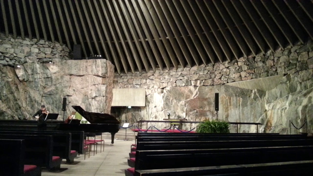 man is playing violin in Temppeliaukio Church