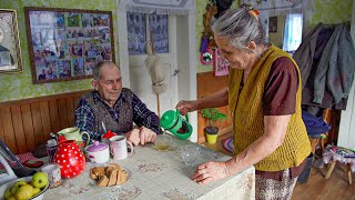 Happy old age of an elderly couple in a mountain village in winter far from civilization